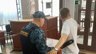 В Татарстане в суд не впустили посетителя с татуировкой на шее в виде герба Третьего рейха